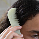 Jade scalp comb gliding through hair