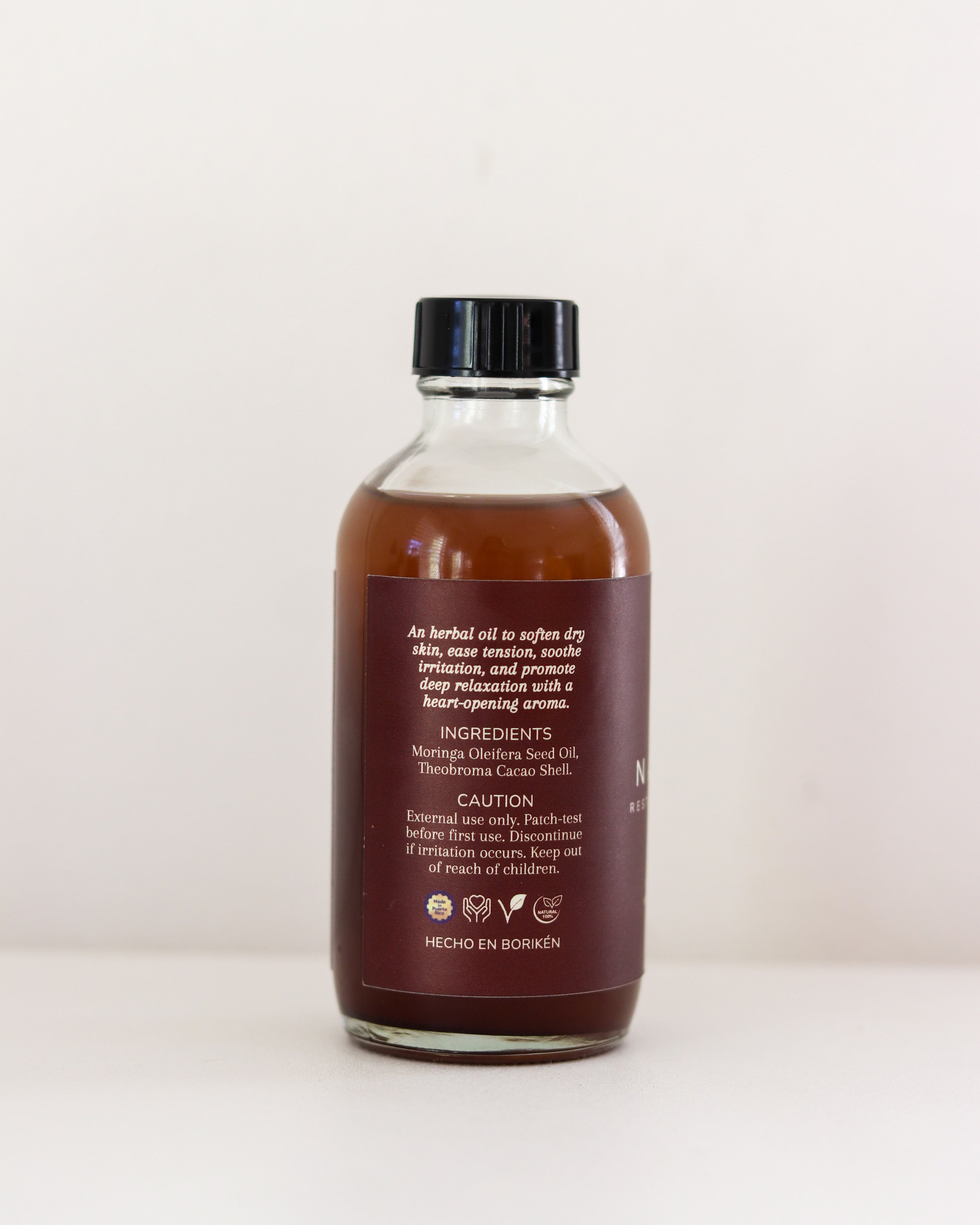 Bottle of herbal oil with a label on a white background